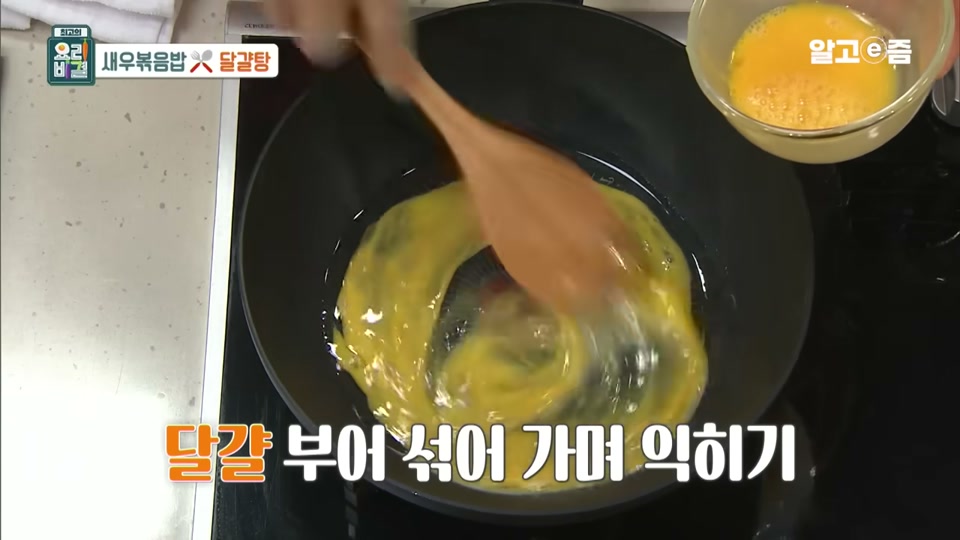 달걀을 부어 섞어 가며 익히는 장면