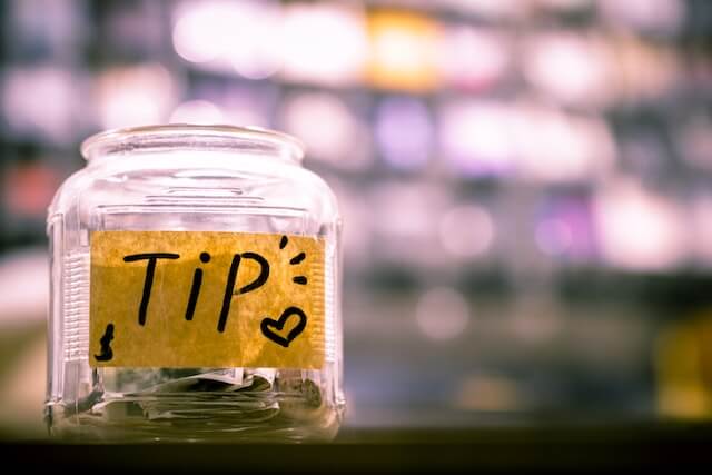 There is a jar for some tips on the table.