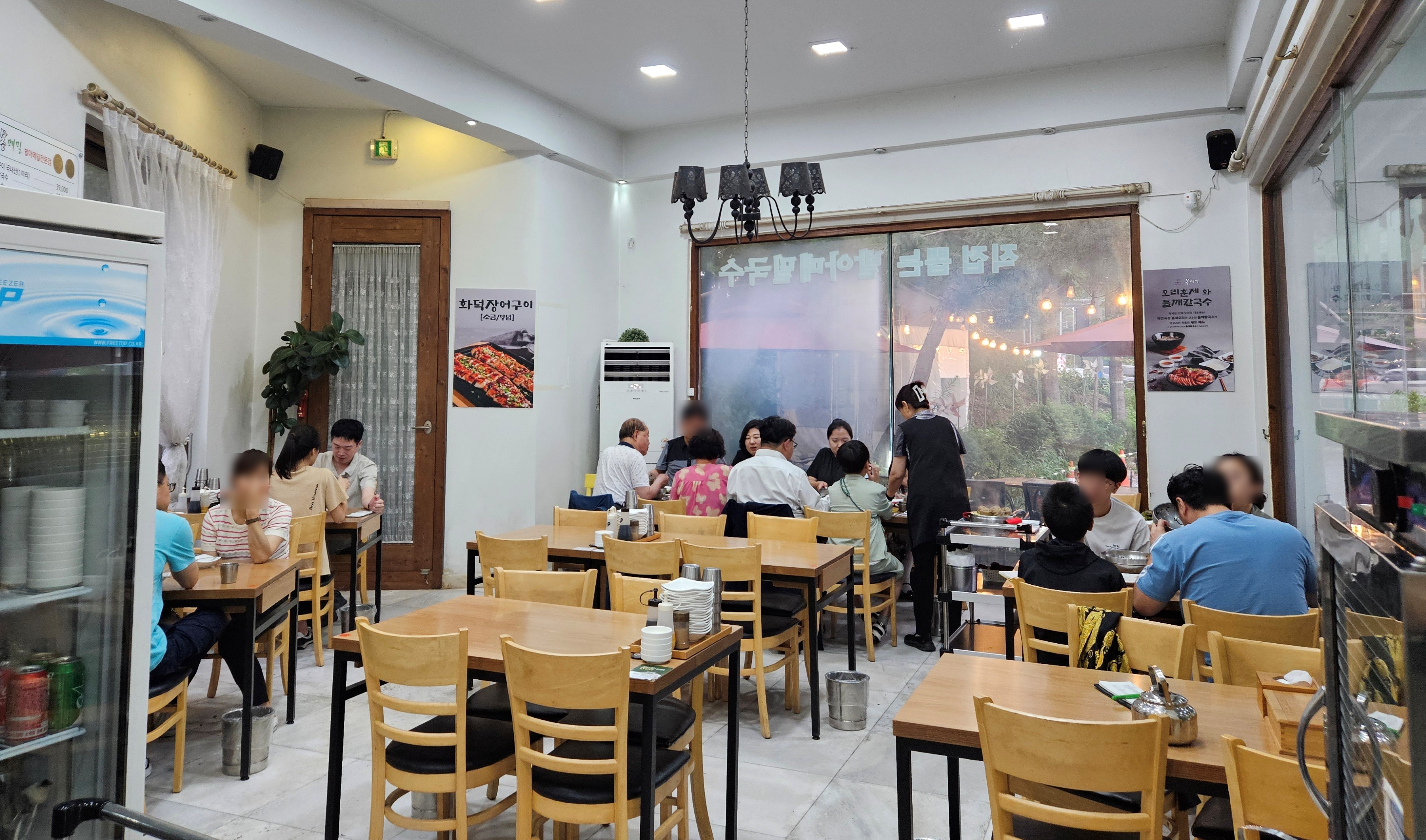 봉메밀-실내-1층-테이블에-앉아서-식사하는-사람들