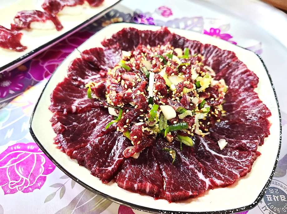 커다란 접시에 한우 생고기 위에 육회가 가득 올려져 있고 그 옆에 생고기 초밥이 있는 전주식당의 함평한우 반반 메뉴의 모습