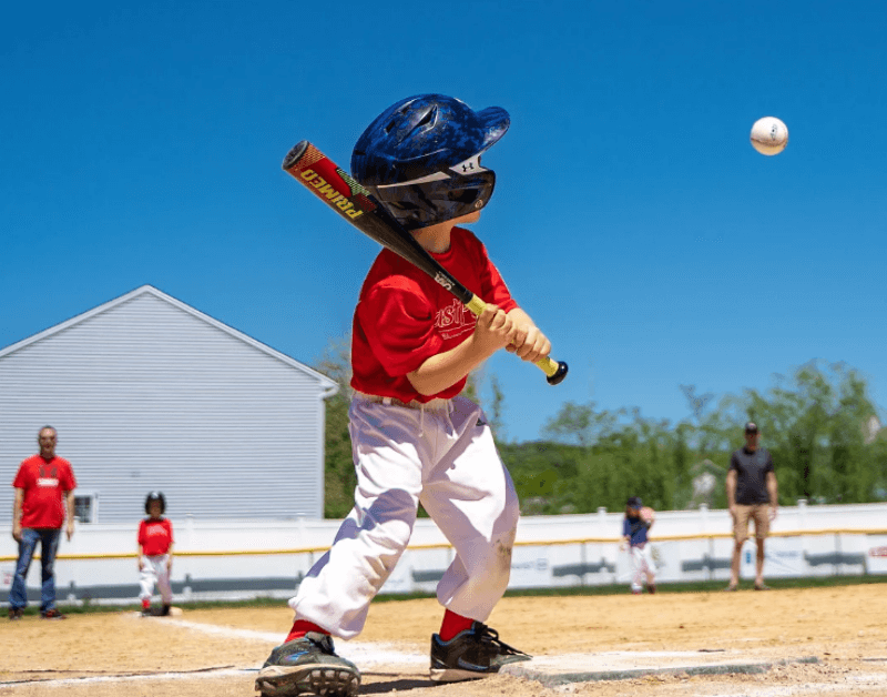 야구방망이 들고 야구공을 주시하는 남자아이 사진