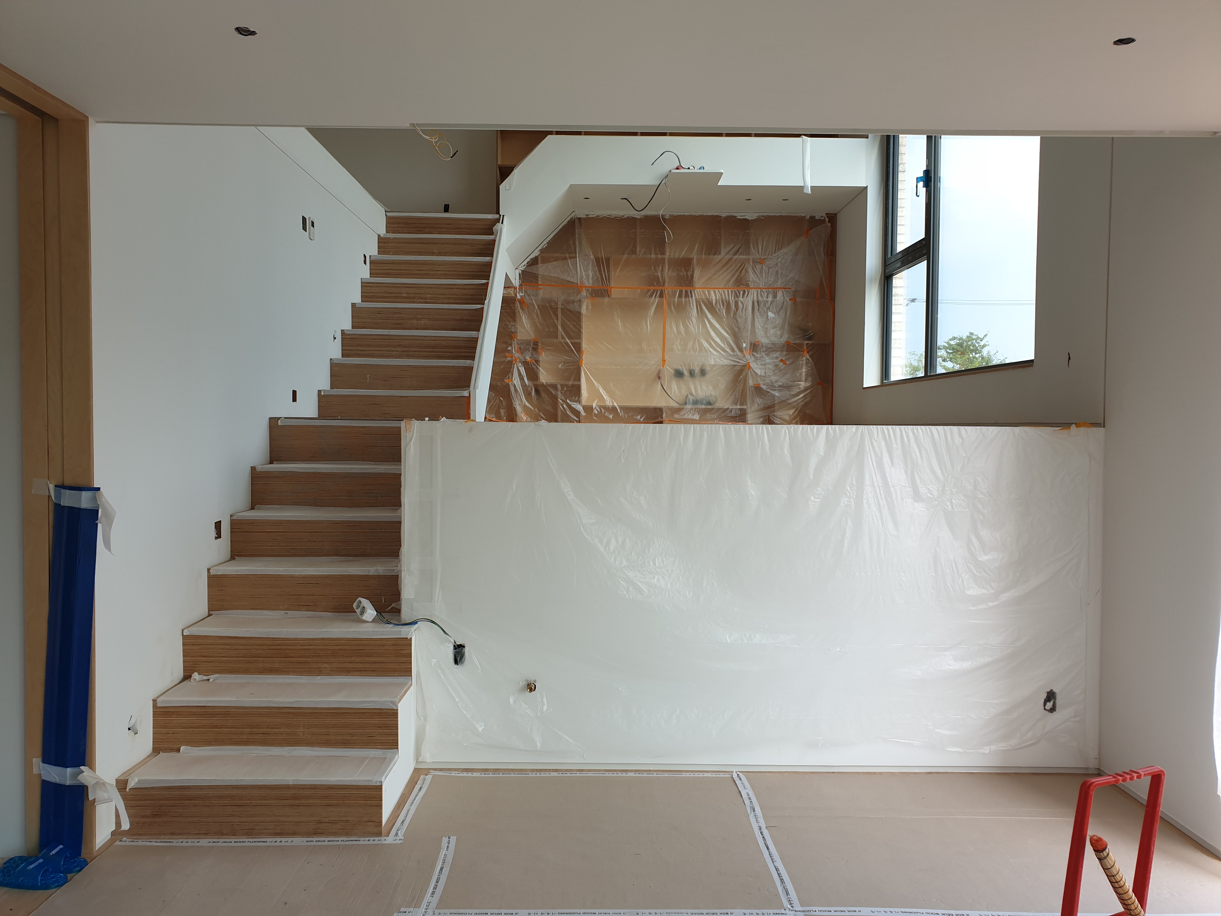 통창이 있는 층고 높은 거실 공간을 시공하고 있는 현장의 모습