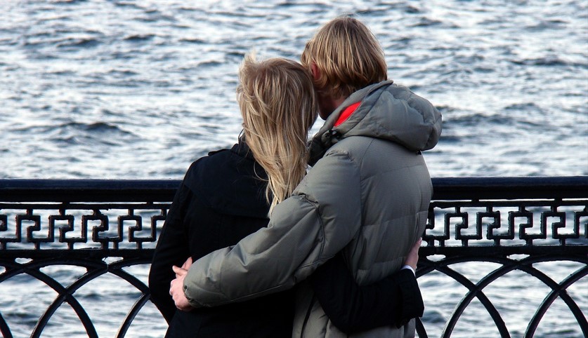 강가에서 데이트하고 있는 연인의 뒷모습을 찍은 사진