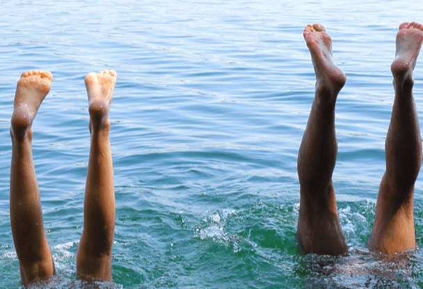 두 남녀가 물 속에 거꾸로 들어가서 4개의 발을 물 밖으로 쭉 내민 모습으로 발바닥이 깨끗하다.