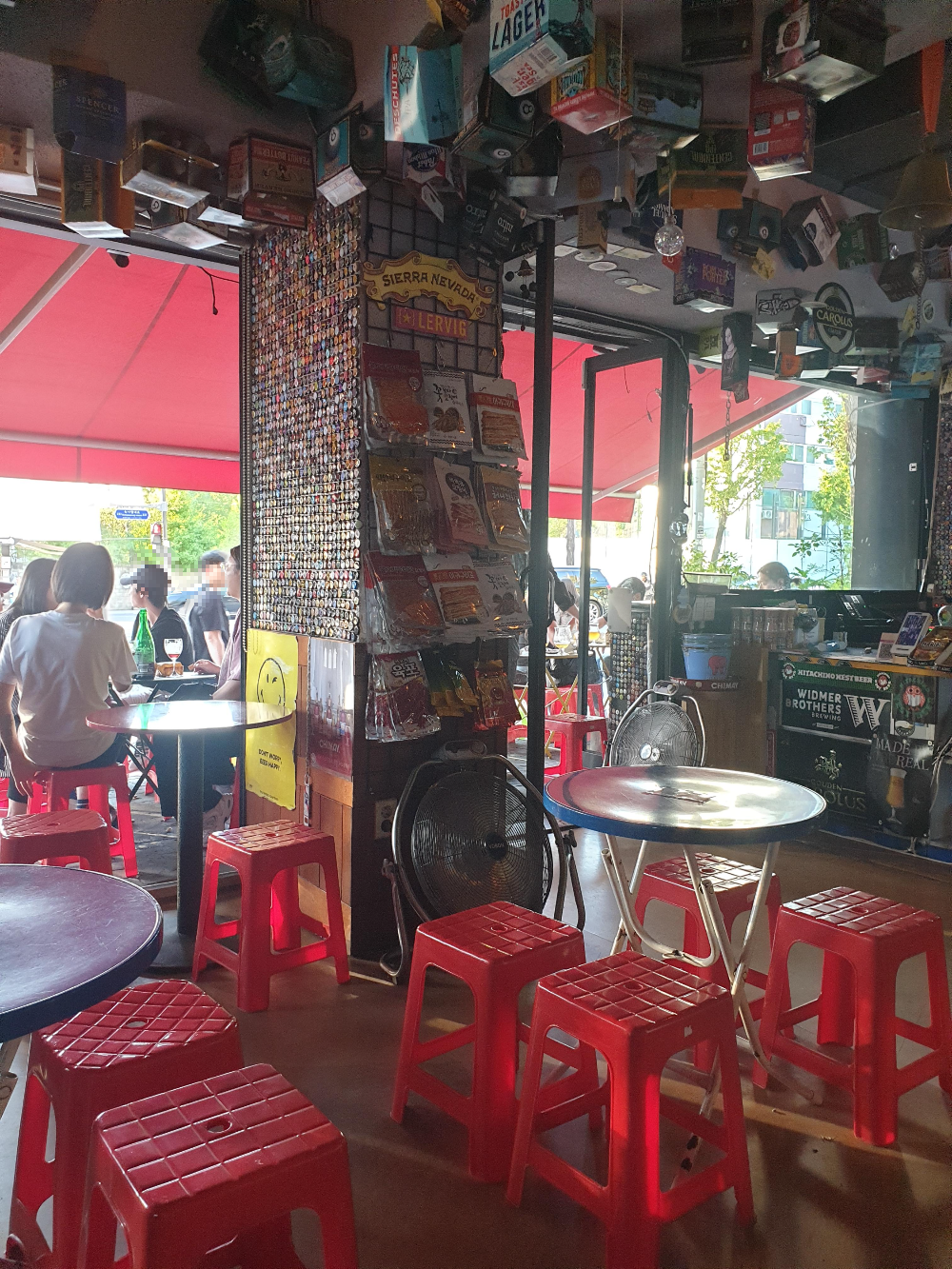 맥주 병마개로 꾸민 기둥과 맥주 박스로 천정을 꾸민 가맥집 우리슈퍼.