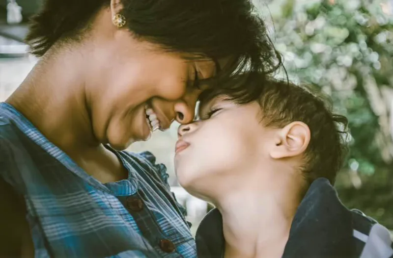 서로 이마를 맞대고 미소 짓는 엄마와 아이