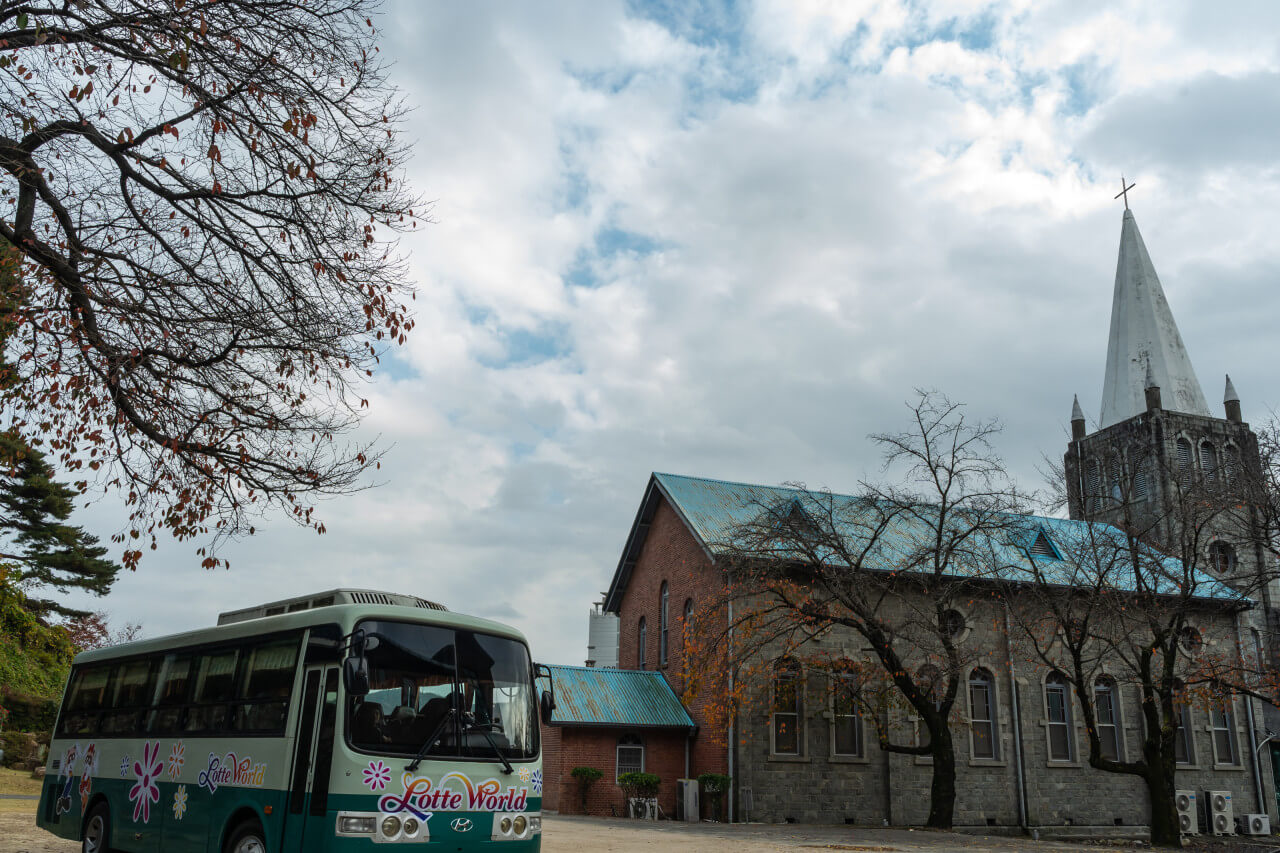 아이들의 보육원을 촬영한 언양 성당 촬영 장소 앞에 놀이공원 버스가 서있는 모습