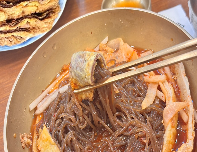 송기원 진주냉면의 섞음냉면을 잘 섞어 육전과 면을 함께 젓가락으로 들어올린 모습