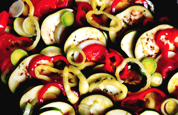 토마토, 가지, 애호박이 섞여있고, 그 위에 잘린 대파들이 올려진 라따뚜이 재료이다. 아직 익지 않은 생생한 모습이다.