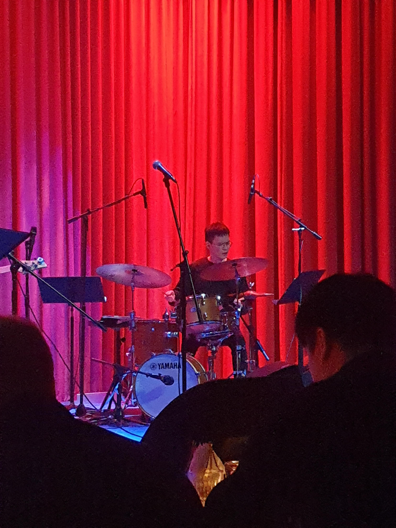 드러머가 연주에 심취해 드럼을 치고 있다.