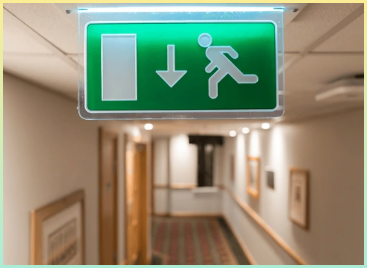 호텔 로비 천장에 걸려있는 일반적인 화재 탈출 간판의 얕은 초점.