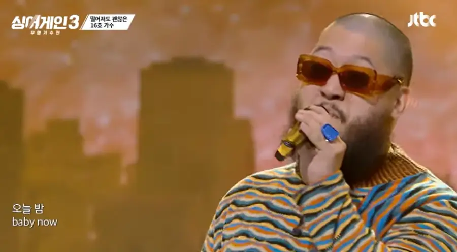 싱어게인3-
황금빛 배경 노랑과 파랑 줄무늬 긴팔티에 검검은선글라스에 왼손 마이크를 들고 노래하는 16호