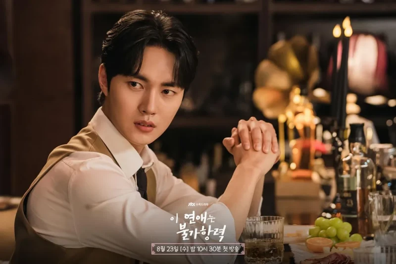 양주와 양주잔이 있는 고급바를 배경으로 와이셔츠에 노랑 조끼를 입고 바에 앉아 있는 이 연애는 불가항력의 김욱 캐릭터