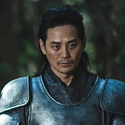 어느 숲을 배경으로 검은 갑옷에 눈 밑에 흉터가 난 아라문의 검 두파 캐릭터