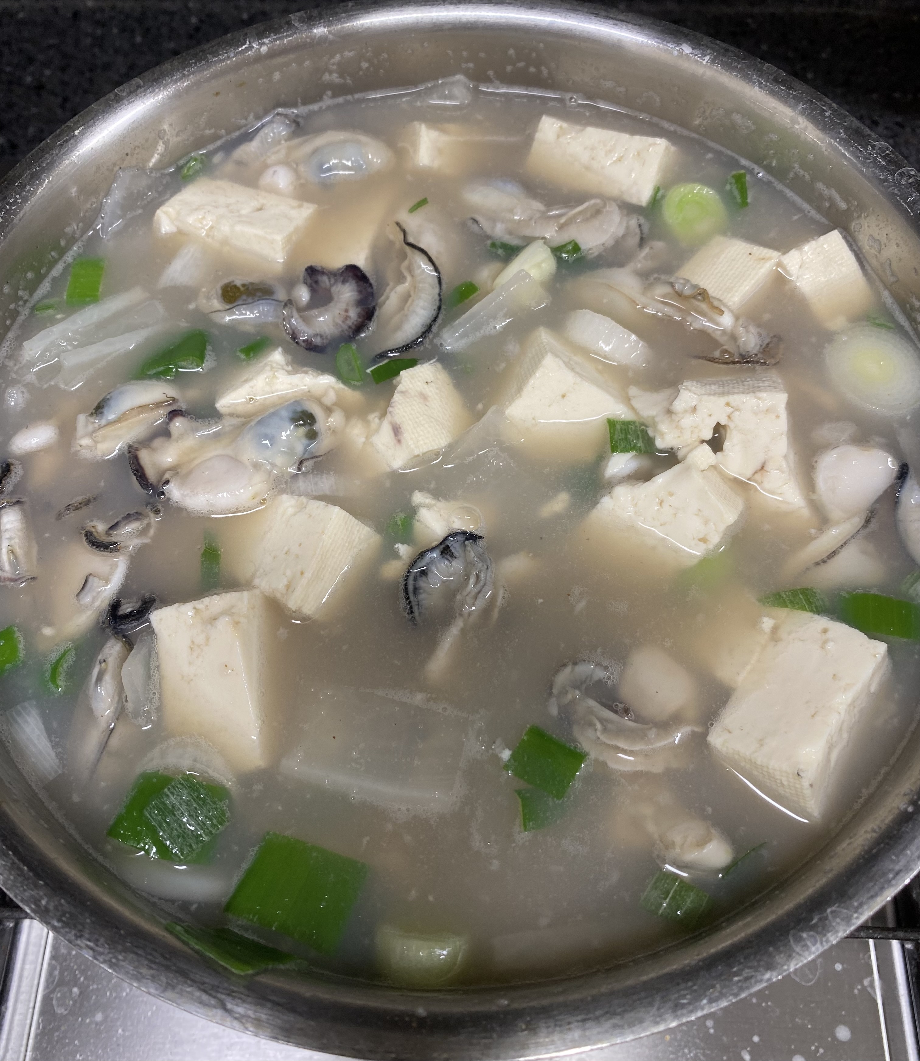 두부 넣은 굴 떡국 끓이는 모습