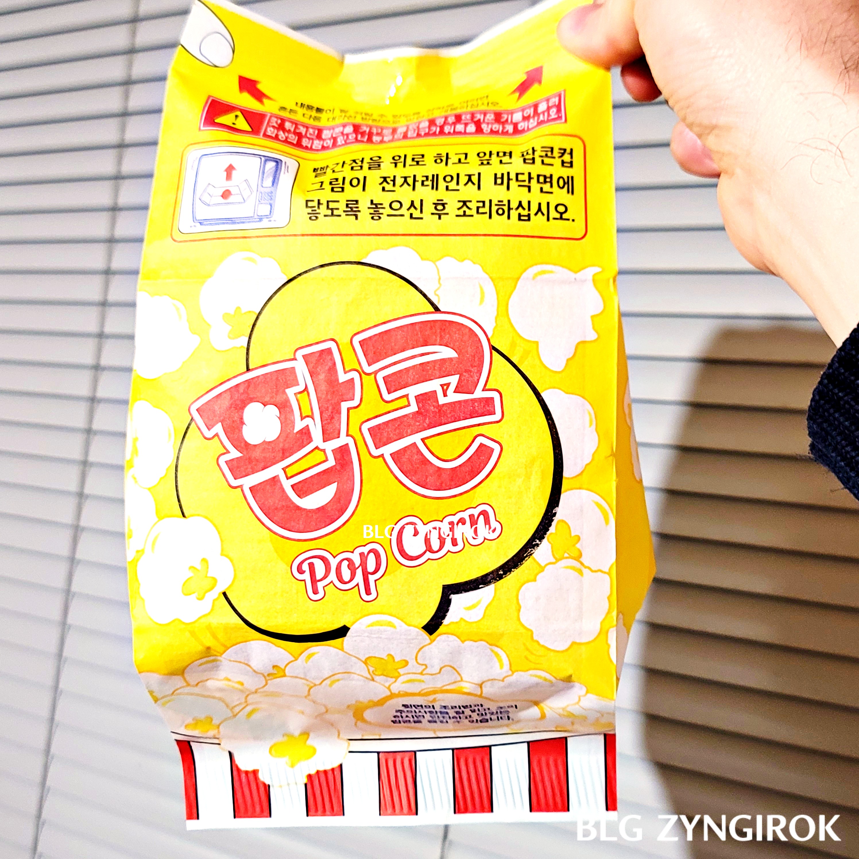 완성된 노브랜드 팝콘을 들고 있다. 봉투가 빵빵하다.