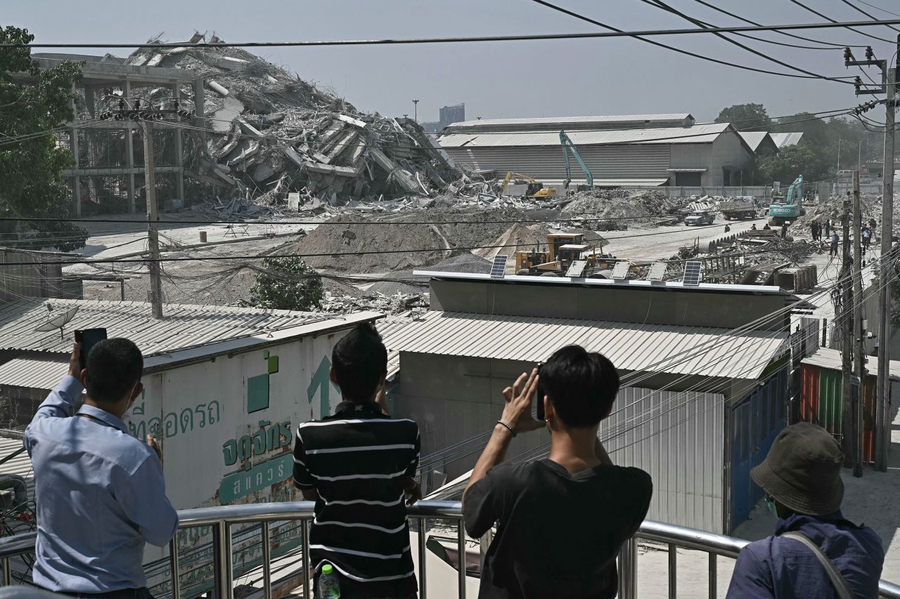 People take pictures of the site where the building collapsed.