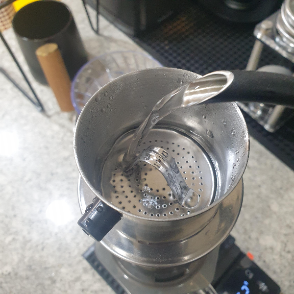 베트남 핀에 드립포트로 물 붓기. 물이 조금 차면 쉬었다 다시 붓는다.