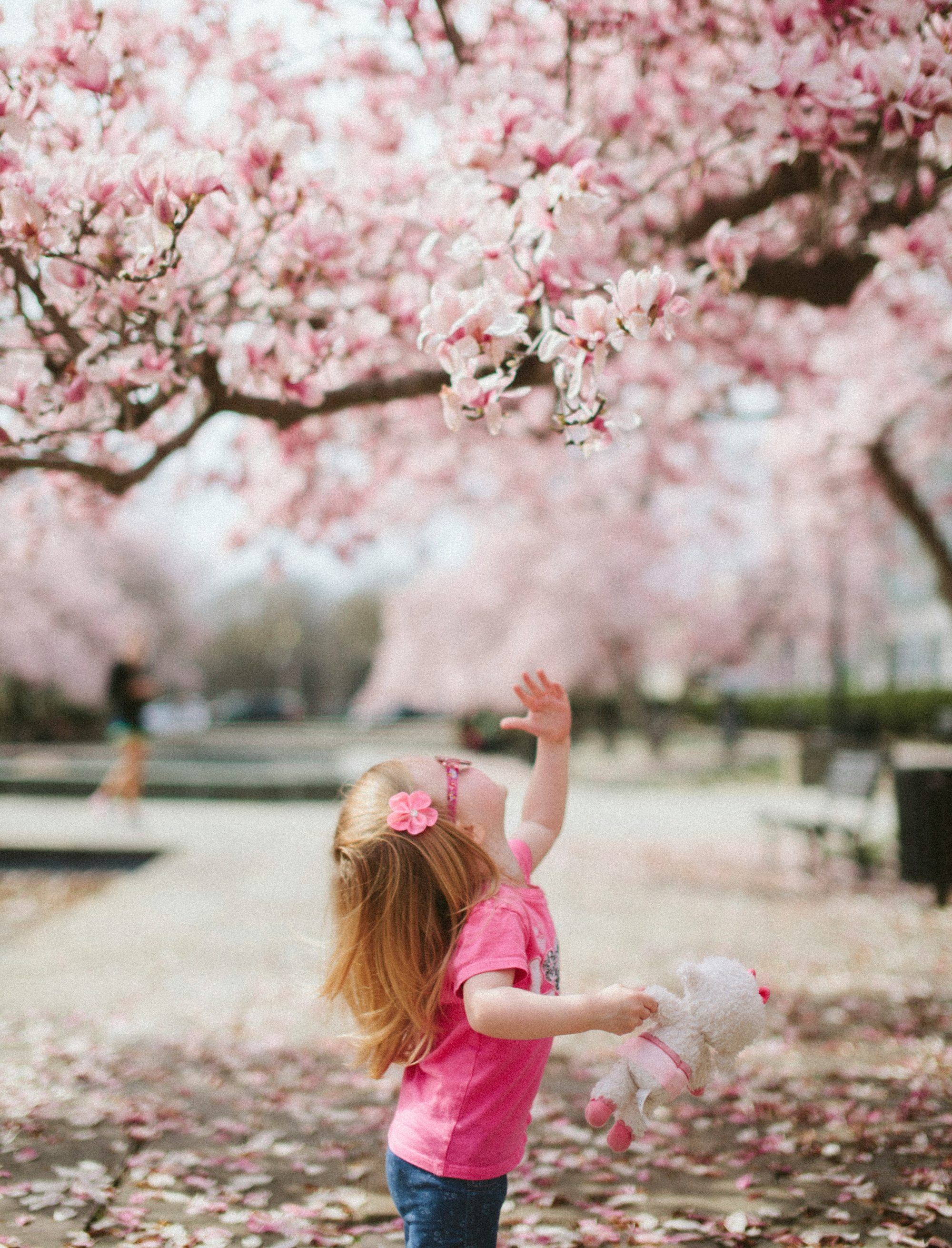 벚꽃 아래에서 놀고 있는 아이의 봄 풍경 이미지 &ndash; 봄철 알레르기 시즌 대표 이미지