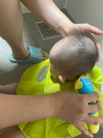 화장실에서 바리캉으로 배냇머리를 밀고 있는 아기 모습