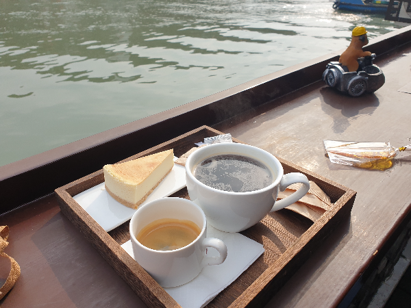 치즈케익과 아메리카노 그리고 에스프레소가 보인다. 바로 앞이 강가다.