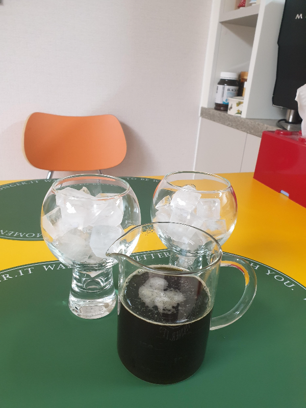 두 개의 얼음 잔과 커피가 든 서버 하나가 테이블 위에 올려져 있다.