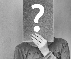사람이 물음표 그림을 들고있다