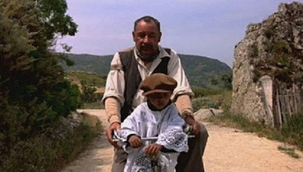 자전거를 타고 가는 중년의 남자와 어린아이, 어린아이가 앞에 걸터앉아 있다.