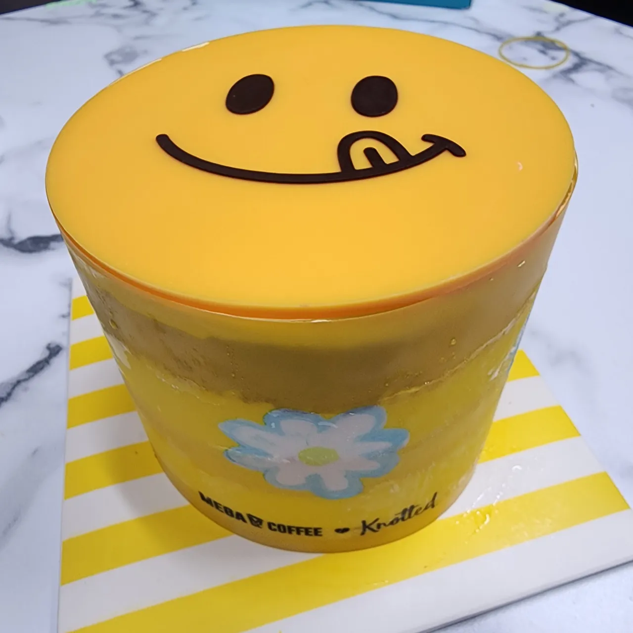 노티드의-노란-스마일-캐릭터가-윗면에-있는-케이크-대각선-샷