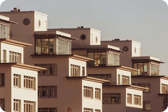 고층 아파트 단지의 외관  일정한 패턴으로 배열된 현대적인 아파트 건물들이 따뜻한 햇빛을 받고 있으며#44; 세련된 도시 분위기를 연출하고 있음.