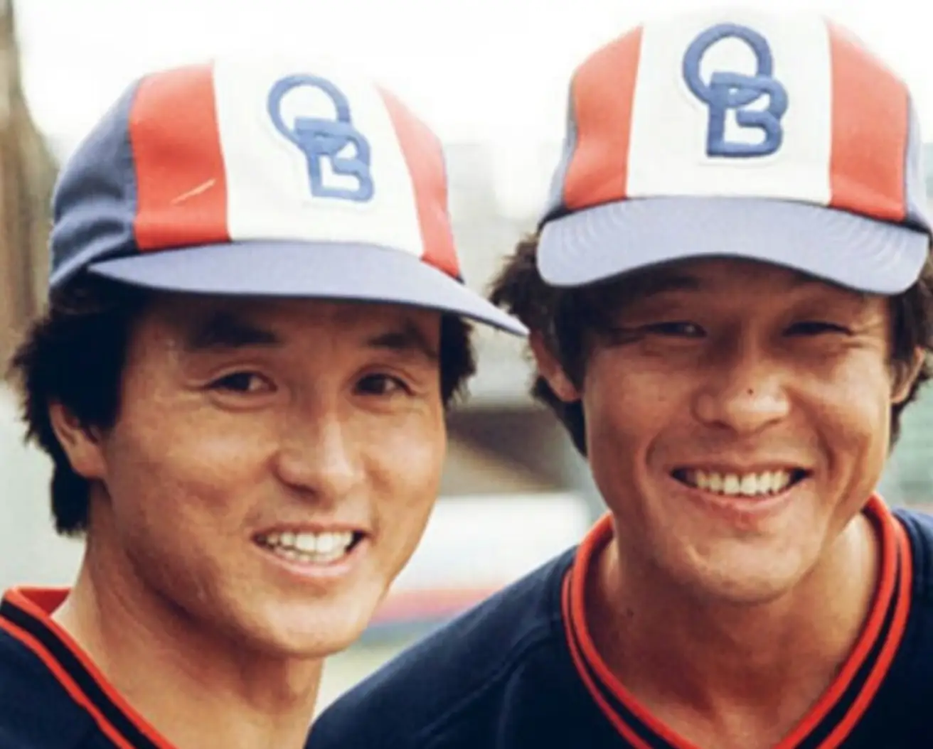 OB글자가 써진 모자를 쓰고 동료와 함께 웃고있는 김경문 감독