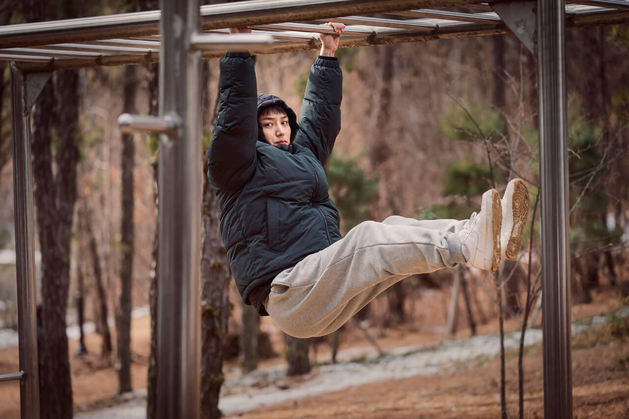 영화 그녀가 죽었다 주인공 구정태가 철봉에 매달려 누군가를 훔쳐보고 있는 모습
