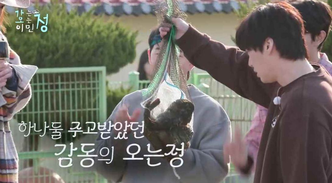 마을주민이 준 생선들이 든 망을 들고 있는 안재현 장면에 하나둘 주고받았던 감동의 오는정 자막이 있는 스틸컷