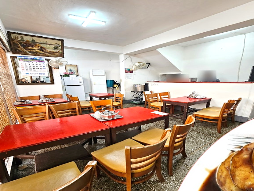 아담한 규모에 빨간색 테이블과 나무의자가 보이는 진주 수복빵집의 실내 모습