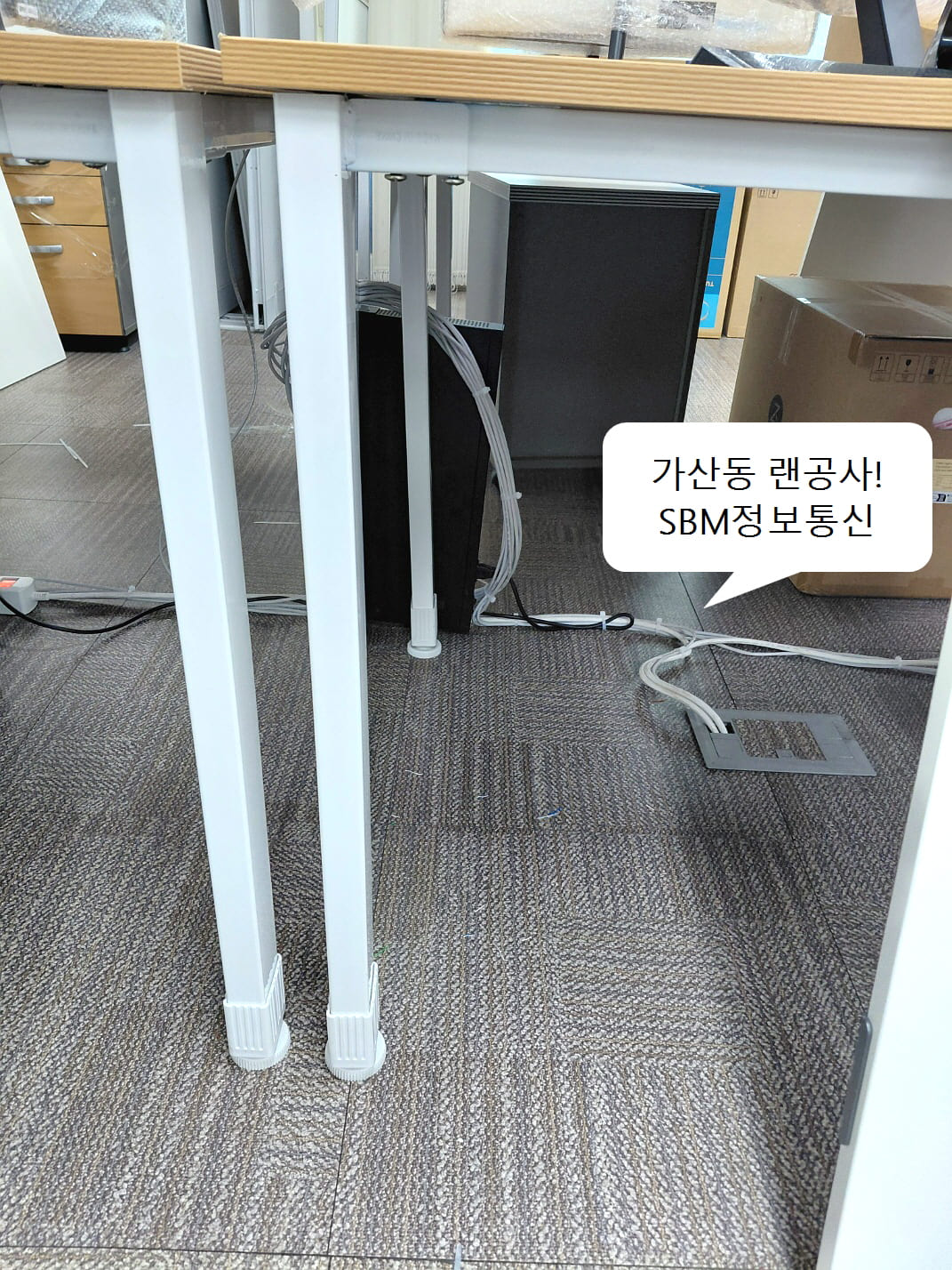 책상 다리를 따라 케이블을 묶어 내리고 바닥 시스템 박스로 깔끔하게 인입되는 모습