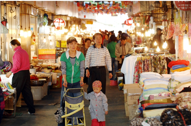 전통시장에서 상인과 고객들이 오가며 장을 보는 모습