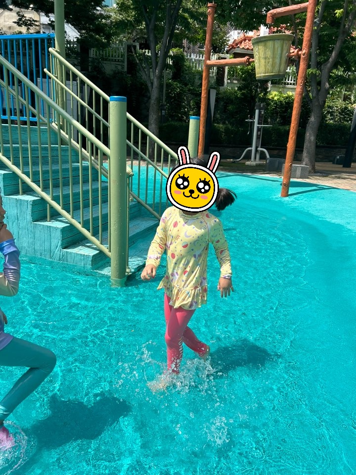 야외 물놀이터에서 즐겁게 땀 흘리며 운동하고 있는 딸의 모습