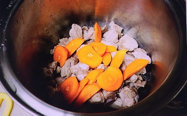 삶아진 고기위에 올린 당근