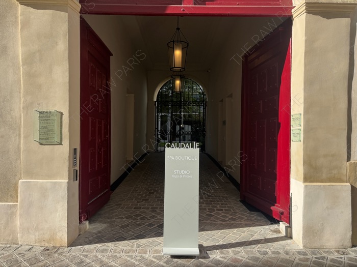 파리 마레 지구 11 Rue Pavée에 위치한 꼬달리 부티크 스파의 붉은목재 문과 입구 스탠딩 간판