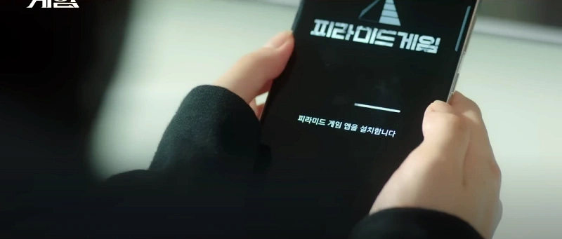 피라미드 게임에서 핸드폰으로 비밀투표하는 장면