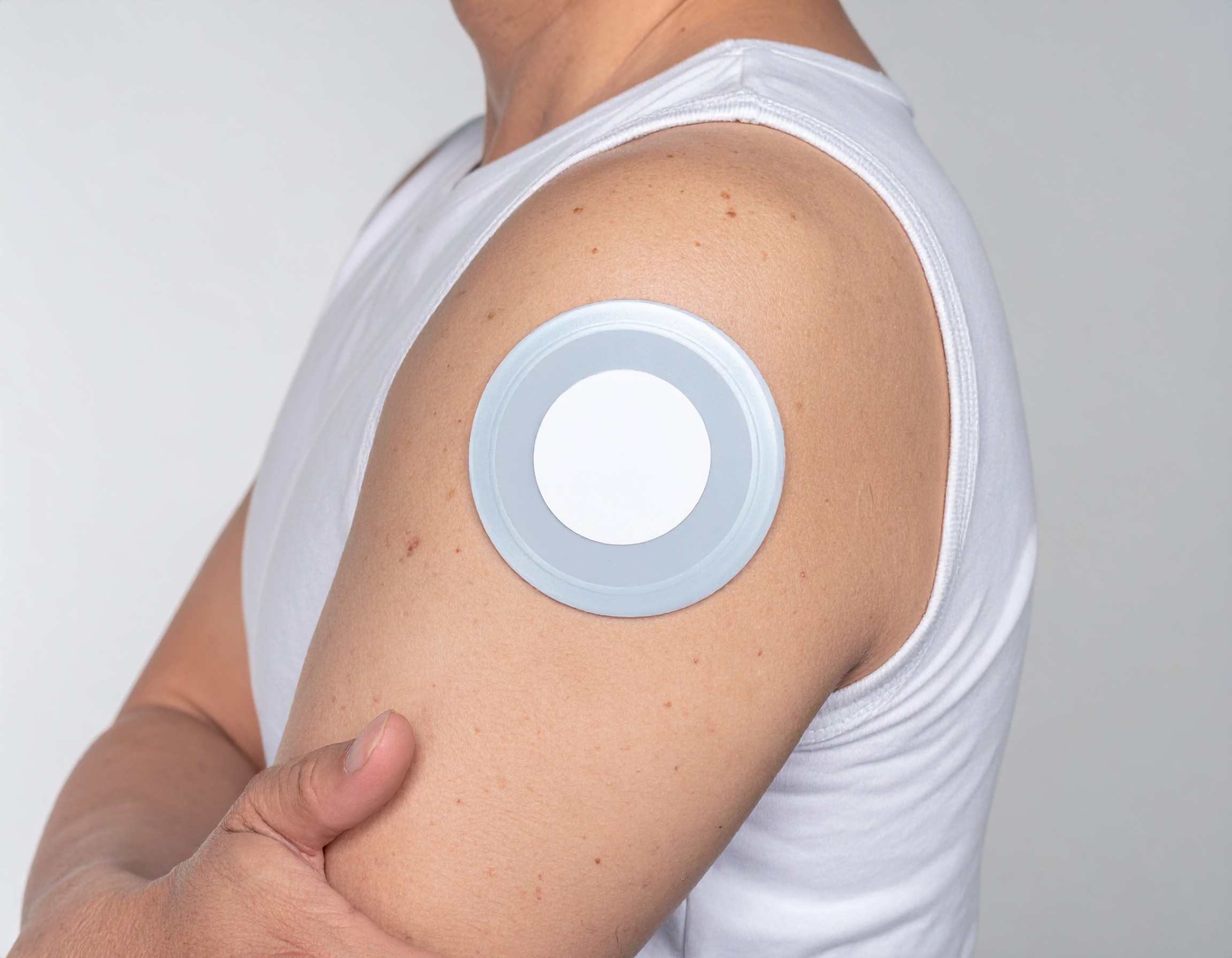팔에 부착된 원형 패치형 연속혈당측정기 센서 CGM 착용 예시