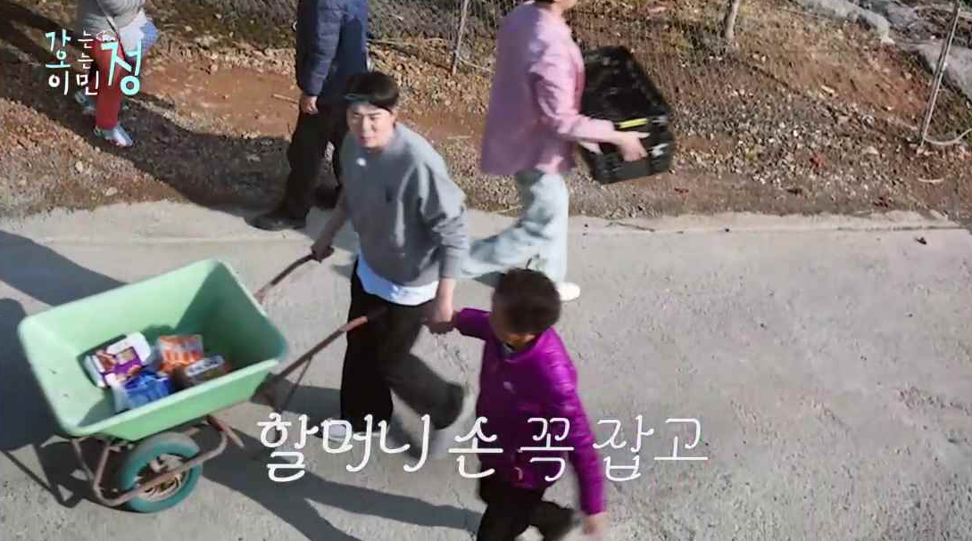 정남매 둘째 붐이 수레를 끌며 할머니 손을 잡고 걸어가는 장면에 할머니 손 꼭 잡고 자막이 있는 스틸컷