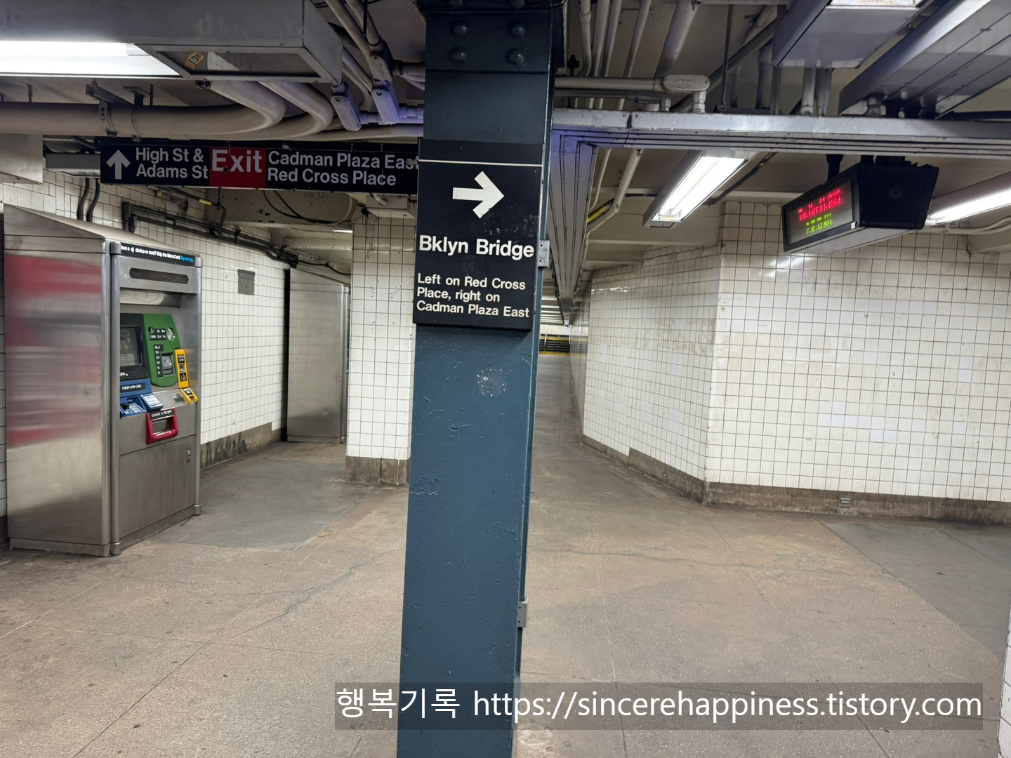 지하철 역내 기둥에 붙은 Brooklyn Bridge 방향 안내 화살표 표지판