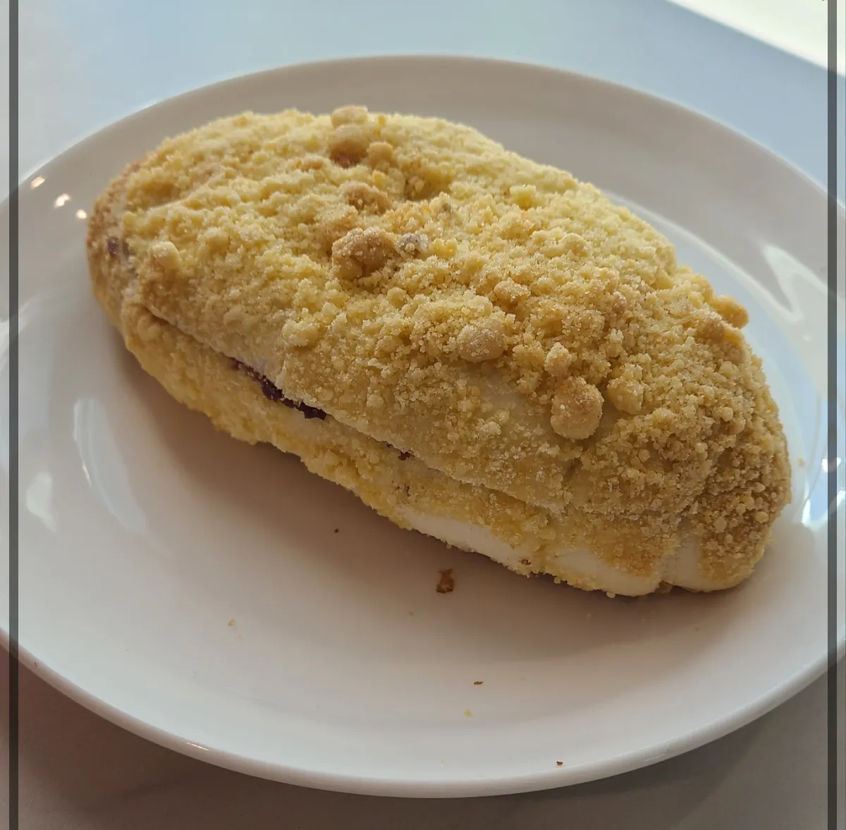 흰접시 위 단팥소보로함초소금빵 빵옆면에 단팥이 살짝 보임