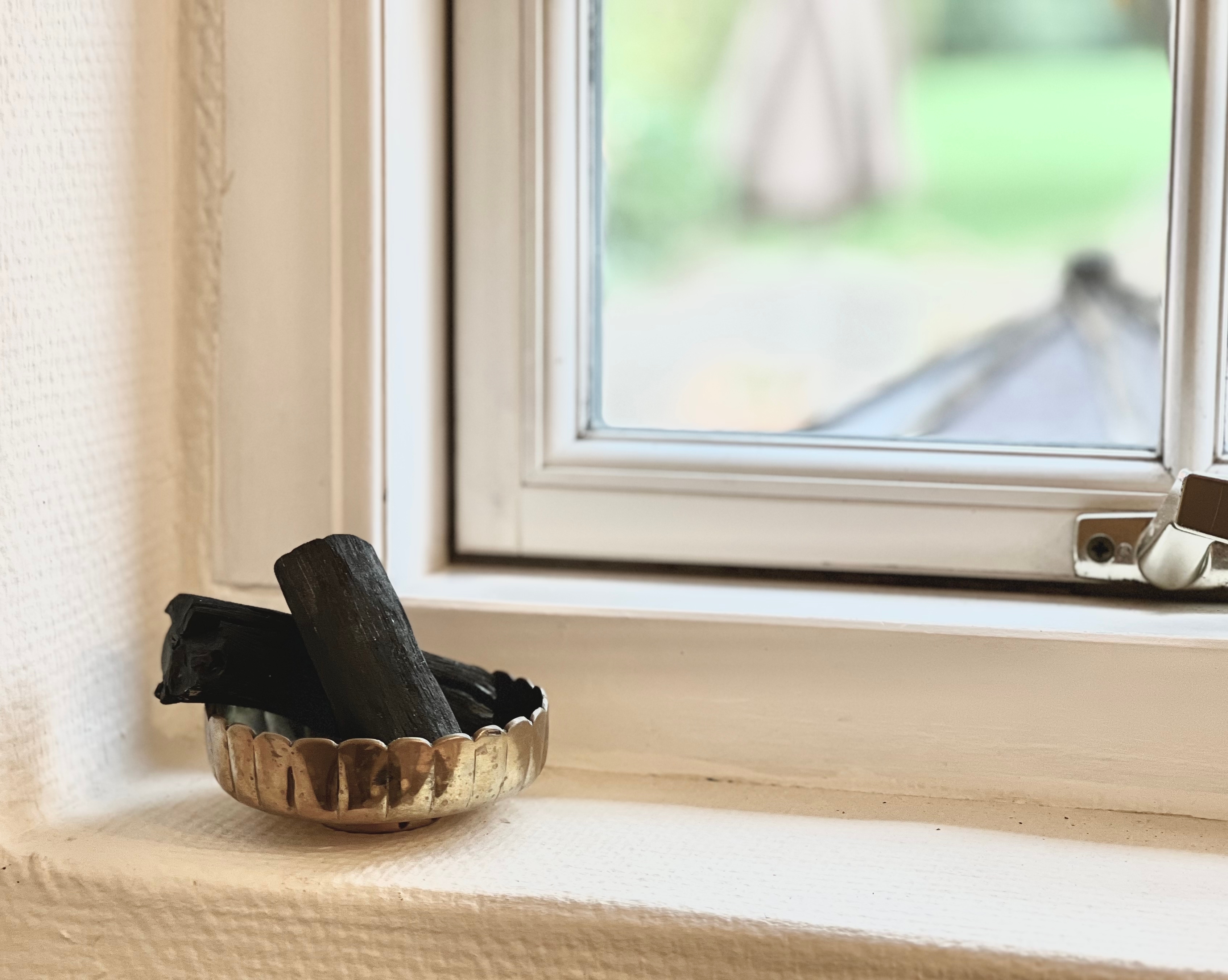 창틀에 놓인 숯을 활용한 천연 제습 방법 &ndash; 여름철 실내 습기 제거용 숯 정리