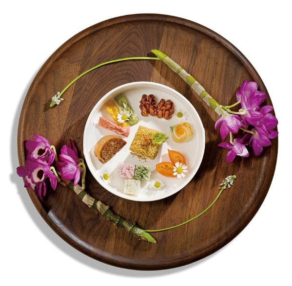 쟁반위에 분홍 꽃과 다과가 담긴 접시