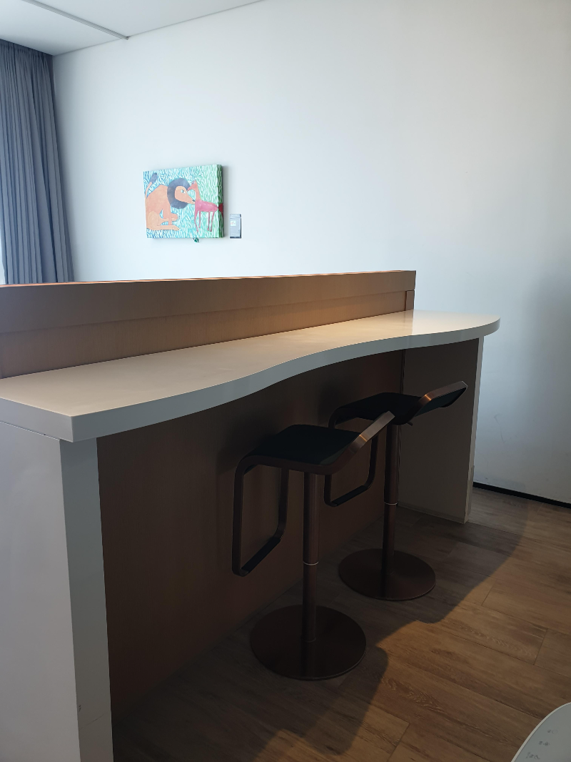 침대 뒤쪽 바. 높은 의자가 두 개 있다.