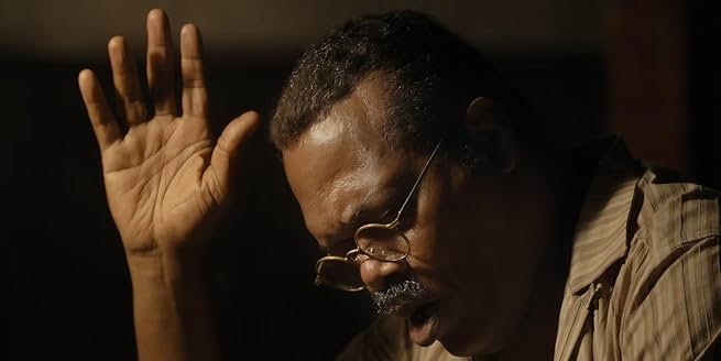 The Piano Lesson 영화에서 기도하는 듯 손을 든 남성 캐릭터