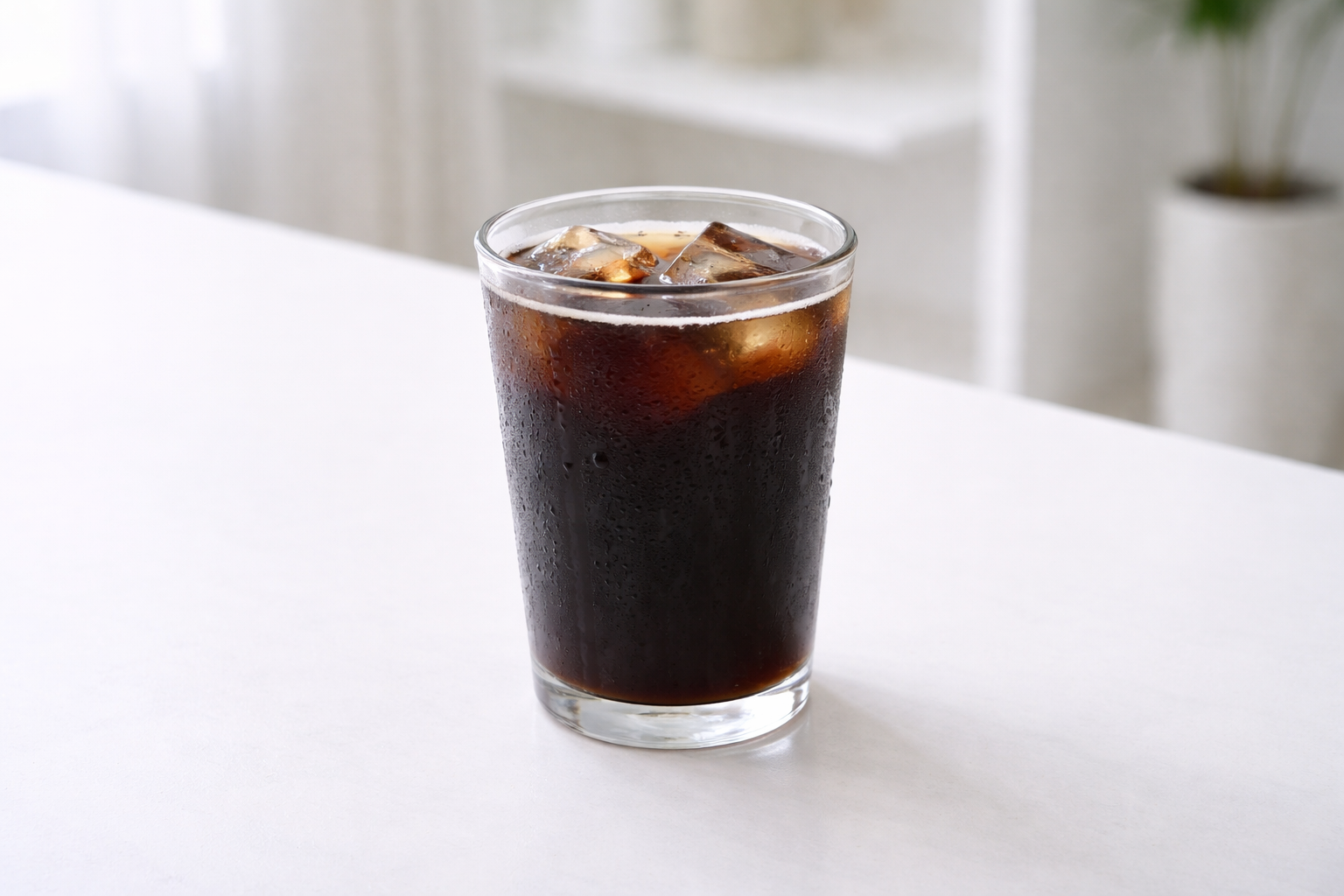 아이스 아메리카노 한 잔이 놓인 카페 테이블 이미지