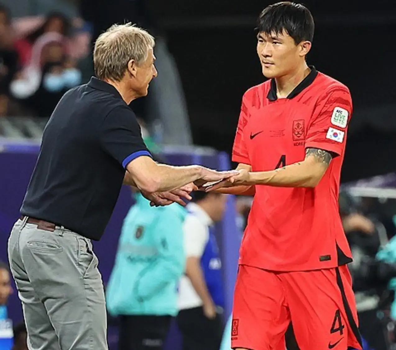 클린스만-축구경기장 검은옷에 회색바지를 입고 붉은 유니폼을 입은 김미내와 웃으며 하이파이브를 하는 클린스만